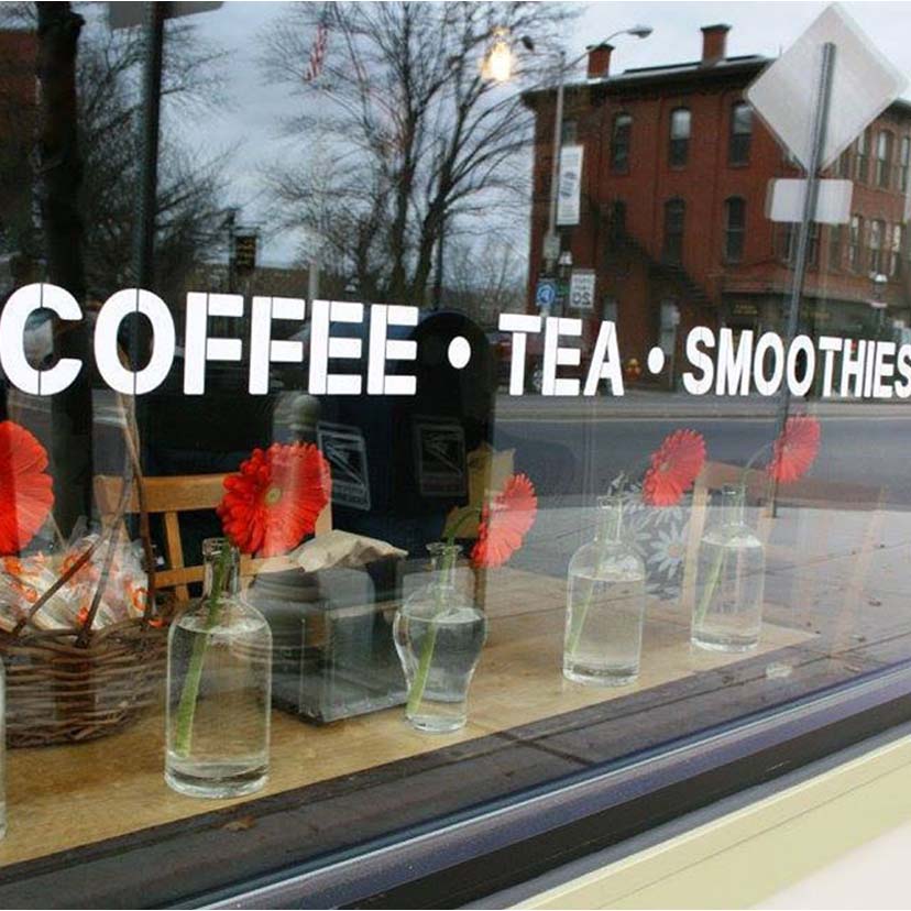 Painted words on a window reading "Coffee, Tea, Smoothies"