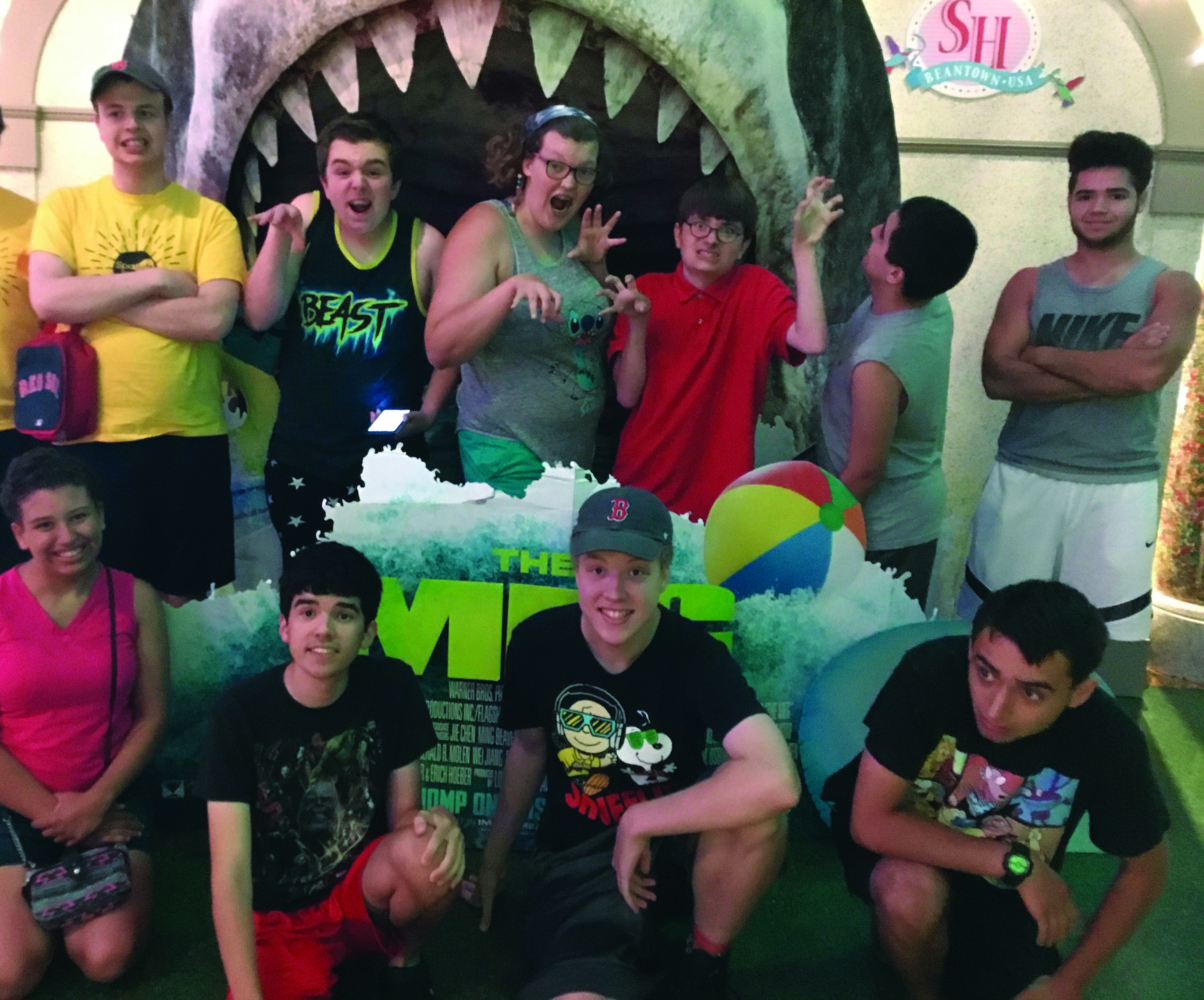 A group of kids post in front of the shark poster