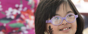 Little girl with glasses and paint on face