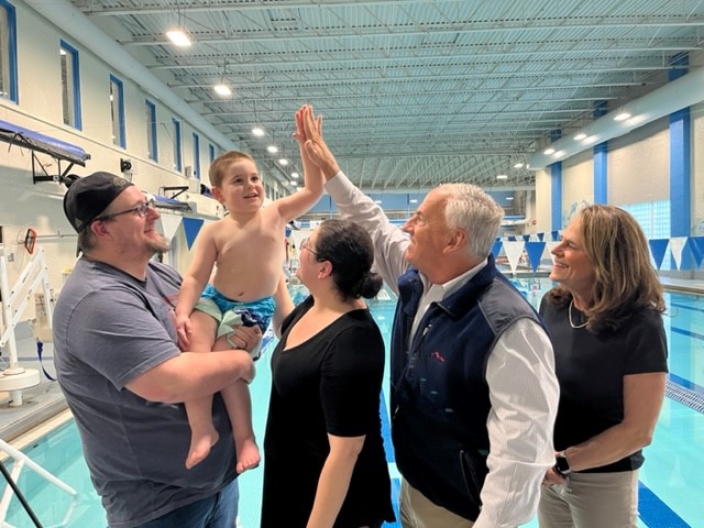 Stephen Rosenthal exchanges a high five with JJ, a participant in the Water Wise program at the YMCA