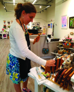 Laura, a Project Parcels program graduate, organizes a display at the store.