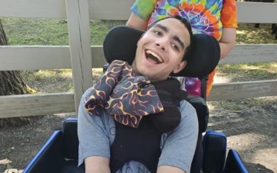 A smiling young man in a wheelchair