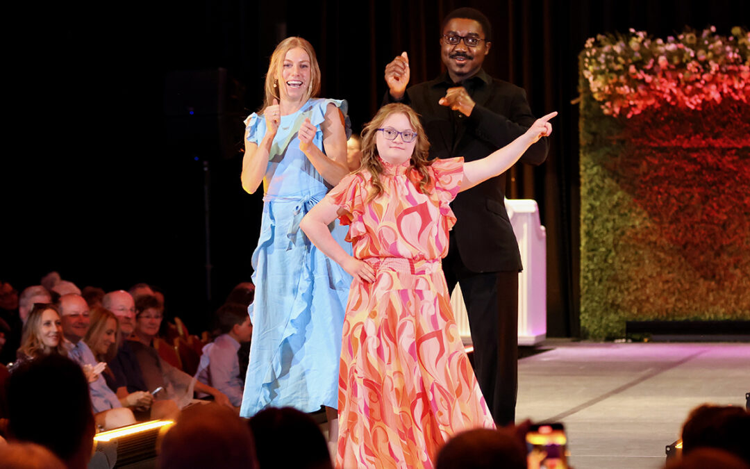 Heather, Cathyrn, and Armahn on the runway during An Evening of Changing Lives Gala