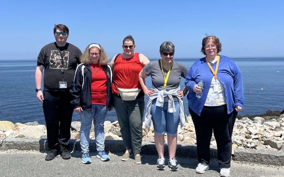 Participants in A Weekend to Remember pose in front of the water in Rockport